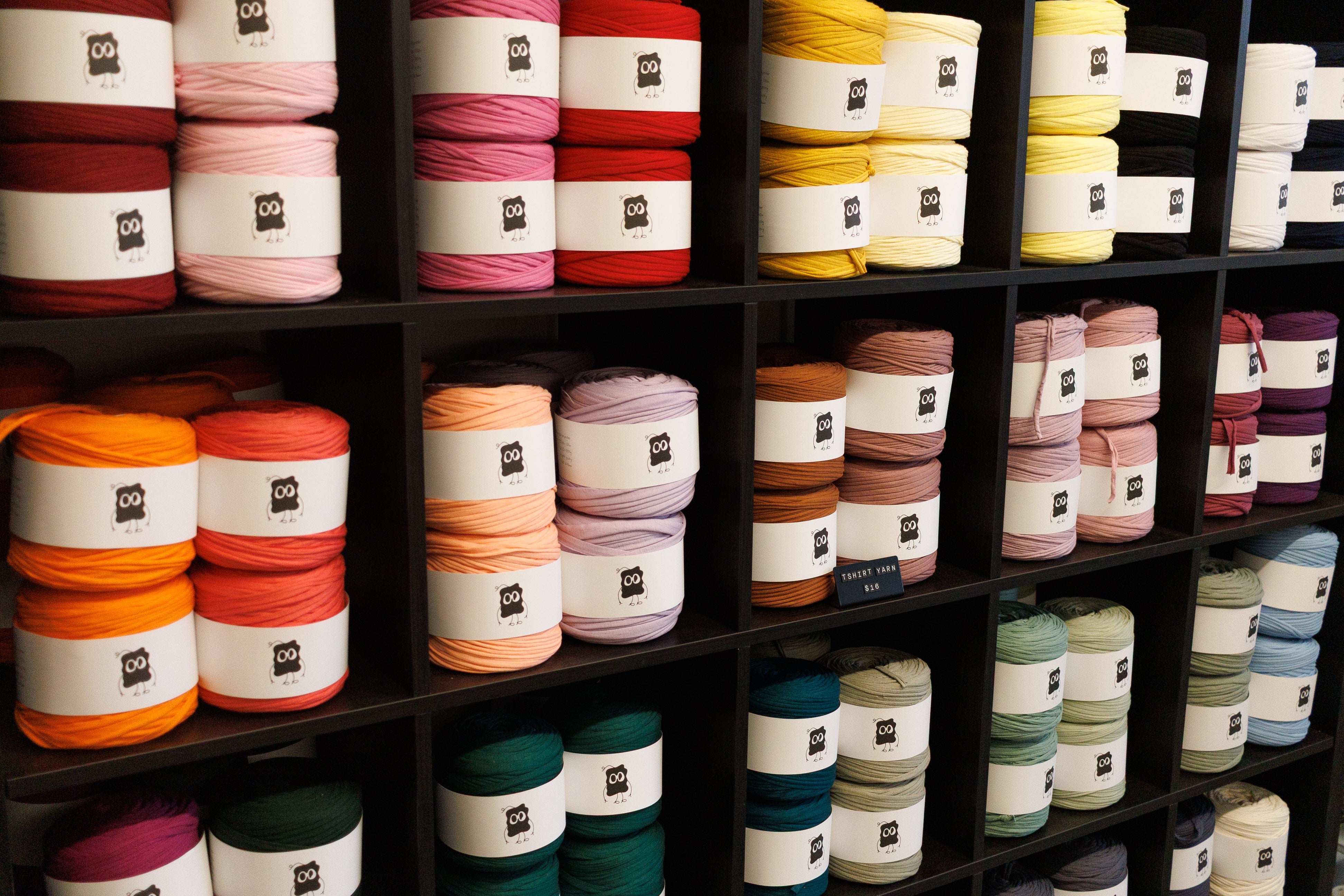 Shelves filled with colorful yarn rolls in a store setting